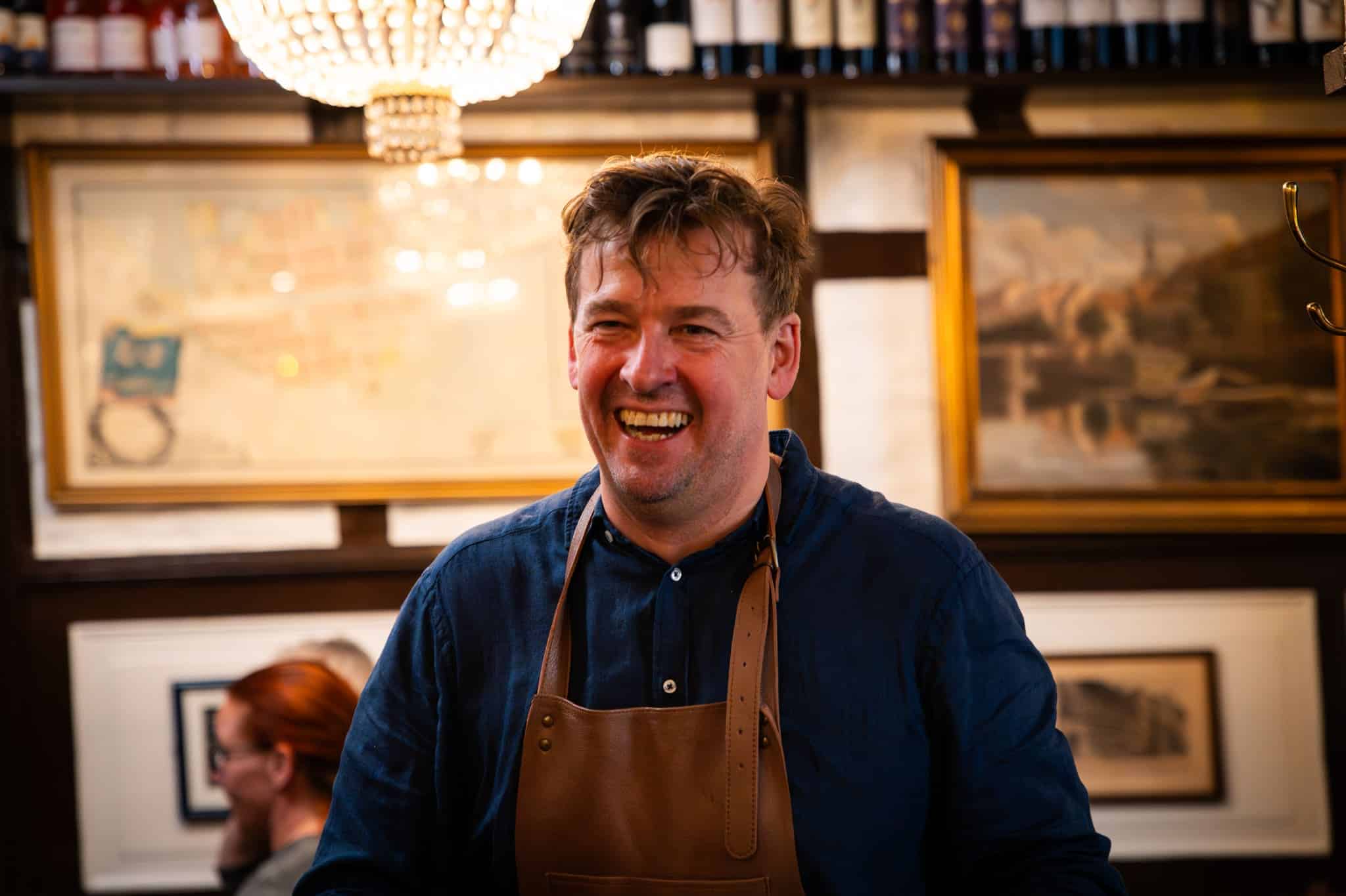 Erik smiles broadly in the restaurant.