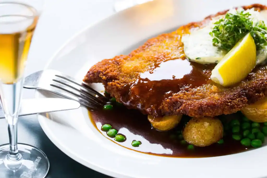 Wienerschnitzel med skysovs og snaps på tallerken