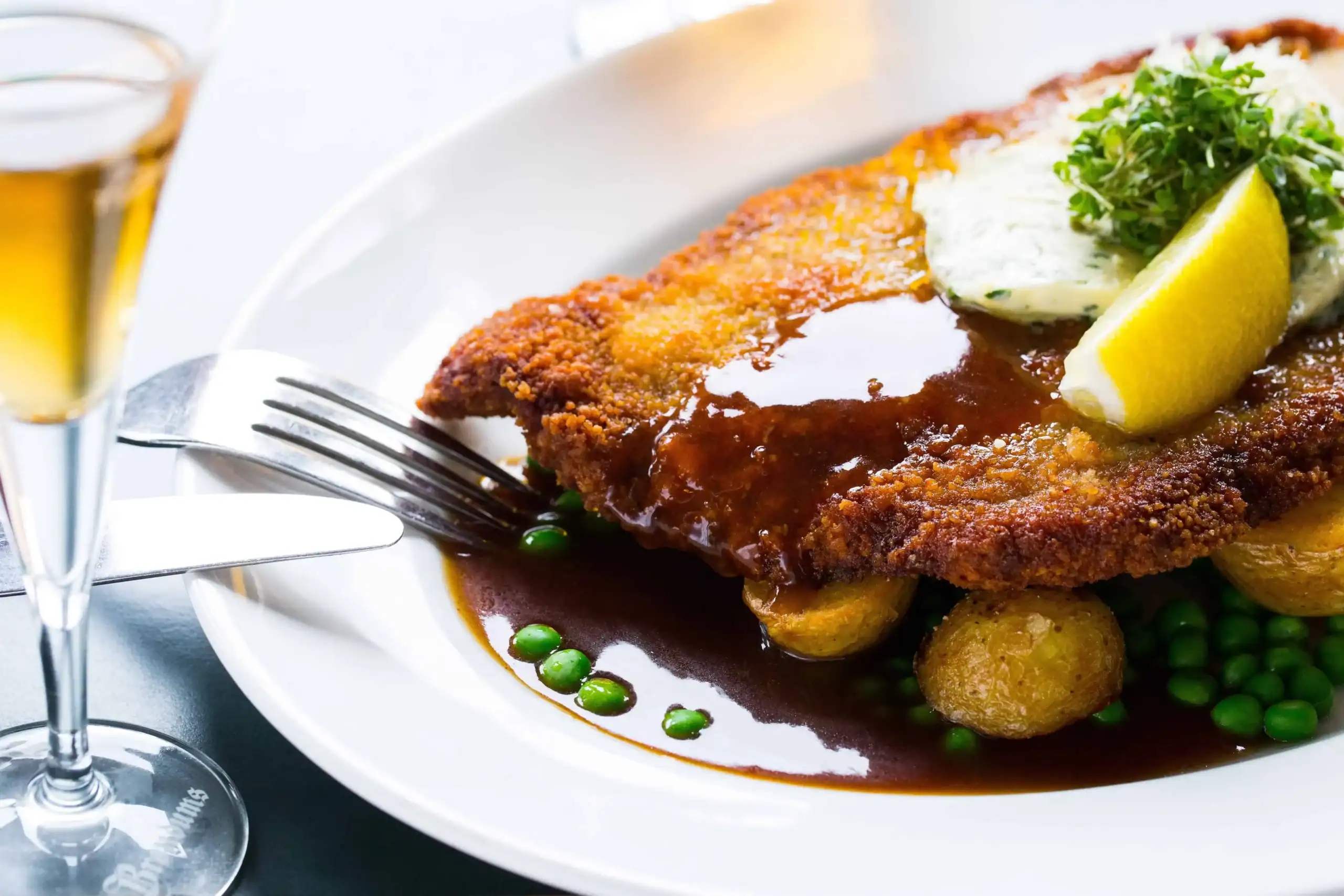 Wienerschnitzel med skysovs og snaps på tallerken