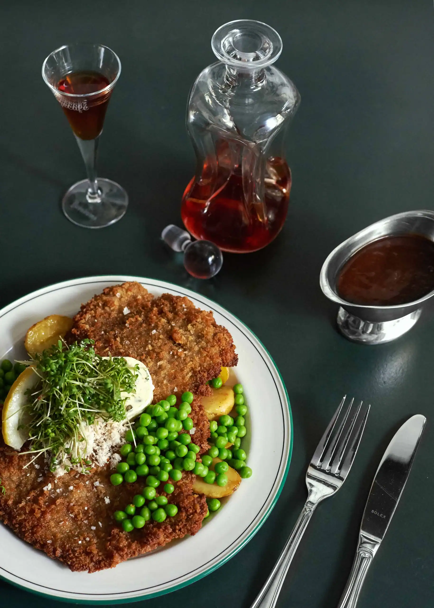 Wienerschnitzel på tallerken serveret med snaps